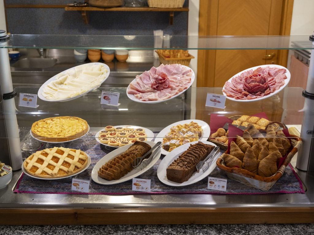 Il banco della colazione con salumi, torte e dolci