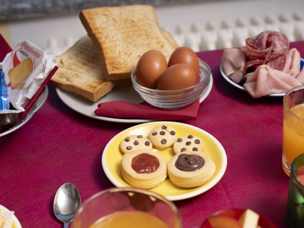 Colazione al tavolo con pane tostato, uova e biscotti