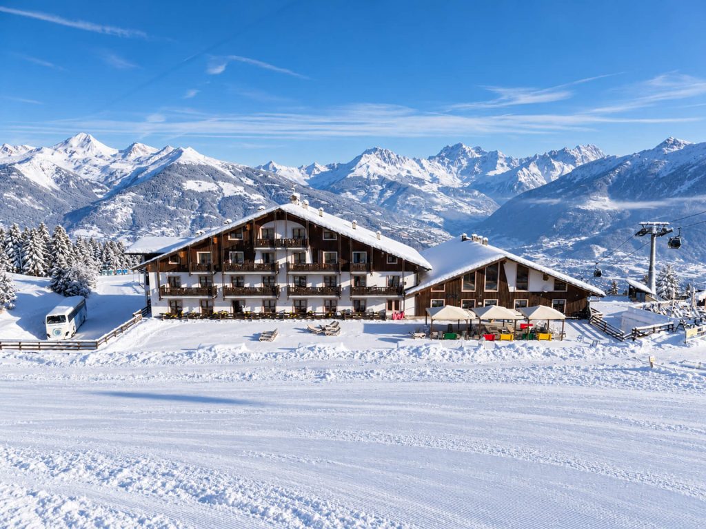L'Hotel Etoile de Neige a Pila d'inverno, con le piste innevate e le montagne sullo sfondo